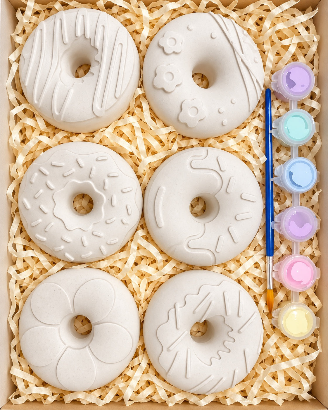 Six doughnut-shaped ceramics with paints and a brush
